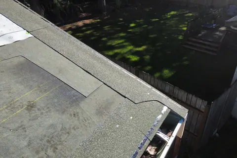A low-slope roof section in Lake Tapps with granulated cap sheet and new edge metal